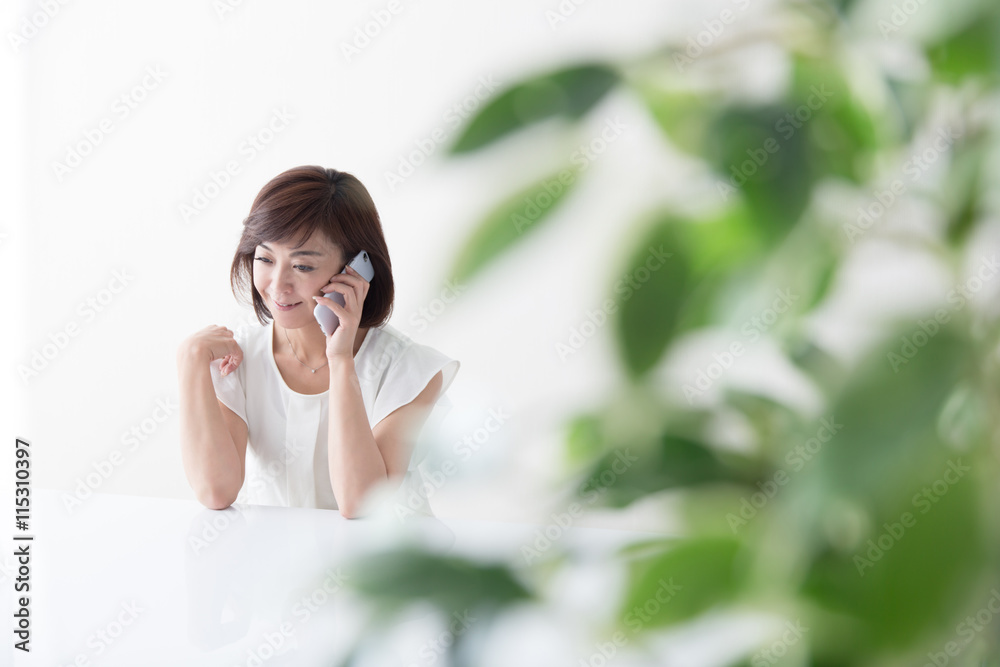 スマホを触るミドル女性・テーブル