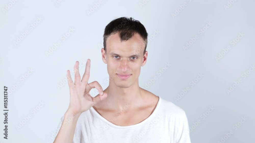 Portrait of a good looking young man with ok hand sign Portrait of a good looking young man with ok hand sign