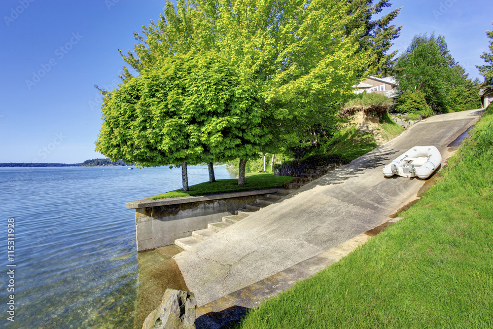 Beautiful landscape with concrete road for boat launching. House exterior.