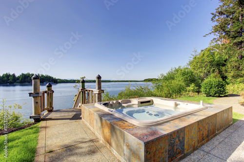 Backyard area with hot tub and awesome water view.