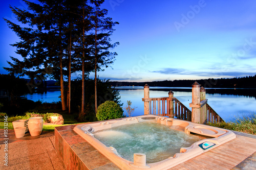 Awesome water view with hot tub at dusk in summer evening.