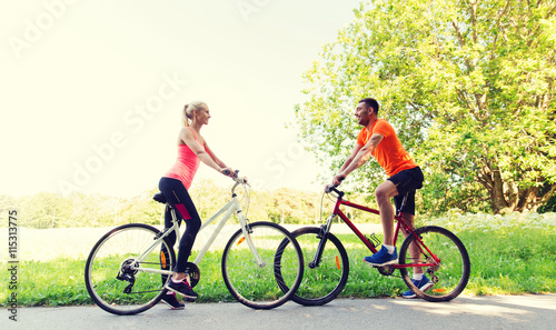 happy couple riding bicycle outdoors
