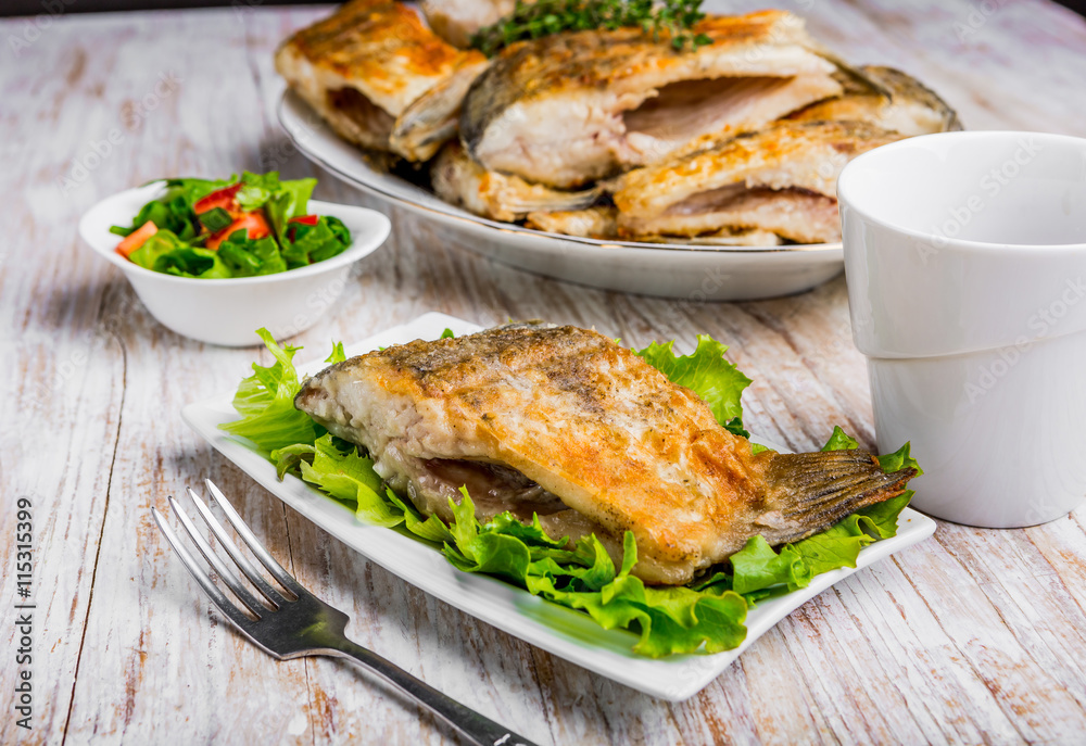 Fried fish with golden crust on a white plate Fried fish with golden crust on a white plate