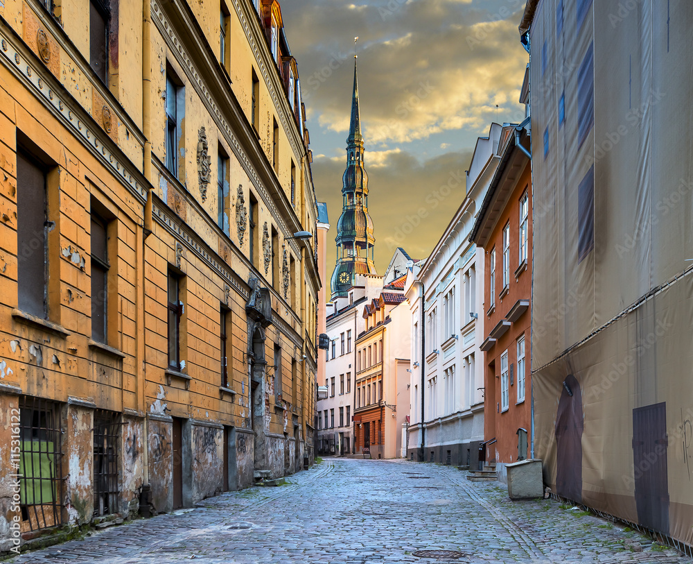 Narrow street in old Riga city, Latvia. Walking through medieval streets of old Riga tourists can feel unforgettable atmosphere of the Middle Ages