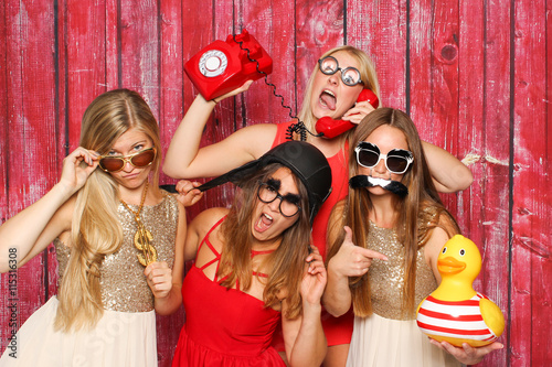 Photo Booth Party mit lustigen Probs - Junge Mädchen albern vor Fotobox herum  photo