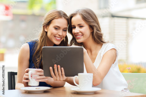 young women with tablet pc and coffee at cafe © Syda Productions