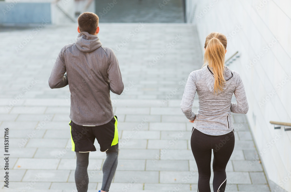 Obraz premium couple running downstairs on city stairs
