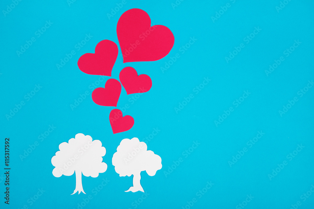 Cardboard figure of trees on a blue background. The symbol love