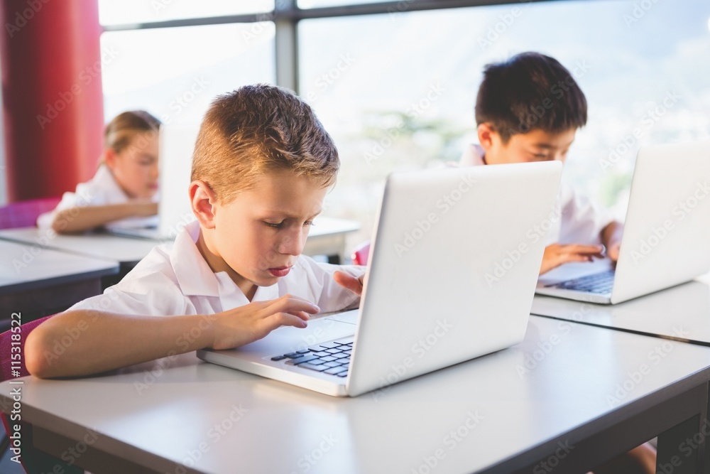 Schoolkids using laptop in classroom Schoolkids using laptop in classroom
