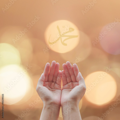 Woman open human hands prayer with palm up and candle night light lantern bokeh with islamic calligraphic symbol text of Muhammed name: Prophet's birthday: Pray supplication concept: God bless Mohamed