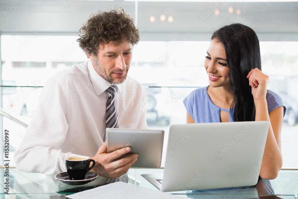 Businessman discussing with colleague over digital tablet Businessman discussing with colleague over digital tablet