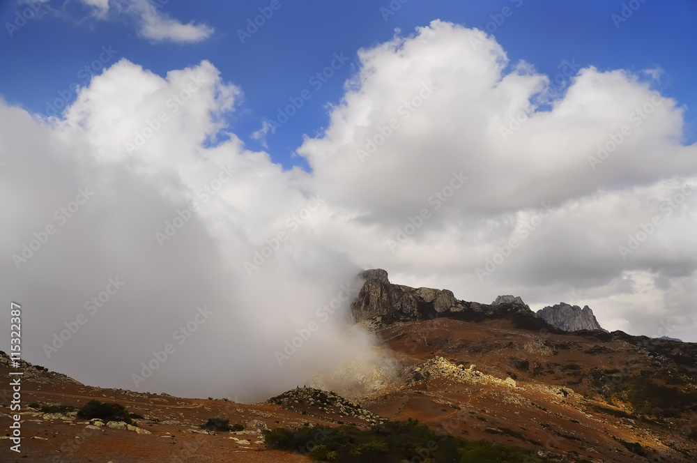 low clouds, crawling on the ground level in the mountains. Sunlight falling on the land plots. Sunny day. The mountainous part of the island of Socotra. Yemen
