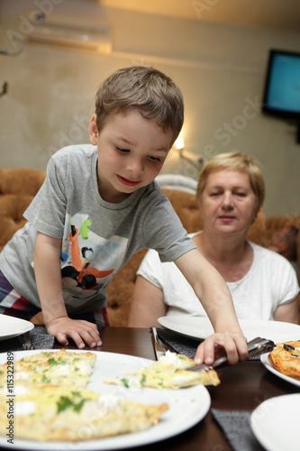 Grandmother and grandson eating pizza