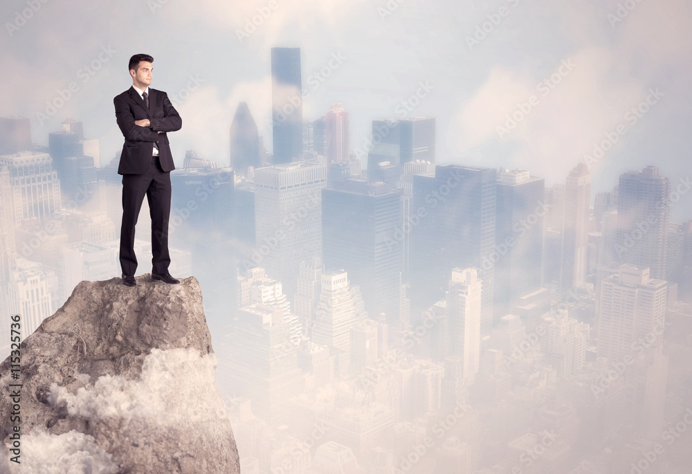 Winner urban businessman on top of stone Winner urban businessman on top of stone