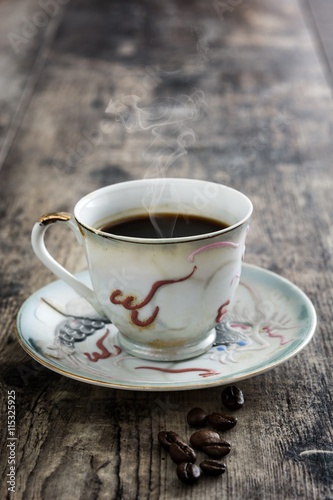 Coffee cup vintage style and beans coffee on a rustic wooden table    