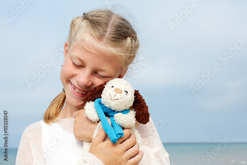 Children psychology. The little beautiful girl embraces an amusi