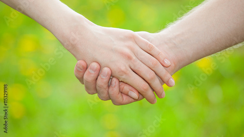 Hands of man and woman holding together