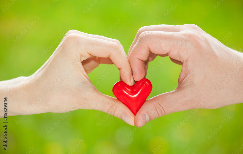 Man's hand proposing a red heart to woman's hand Man's hand proposing a red heart to woman's hand