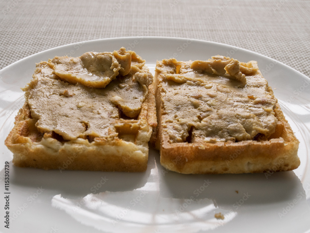 Waffle covered with peanut butter.