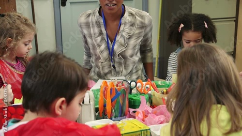 Nursery students doing arts and crafts in the classroom with their teacher.