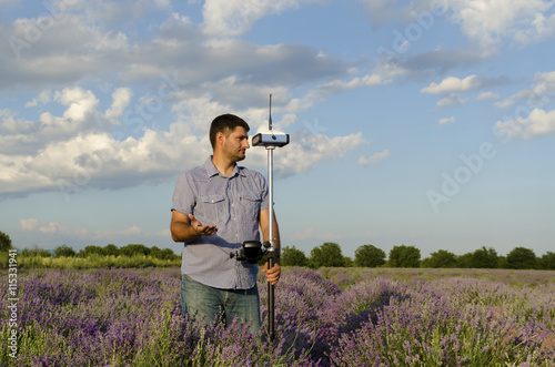 Land surveyor working in a lavender field and waiting for help
