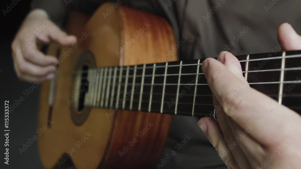 The man plays on a classical acoustic guitar The man plays on a classical acoustic guitar
