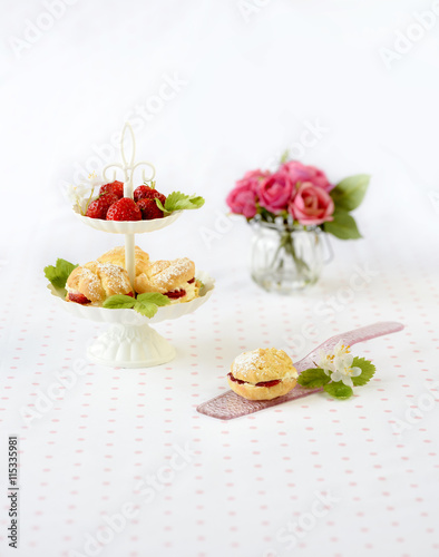 Homemade cream puffs or profiterole filled with whipped cream served with strawberries in plateau