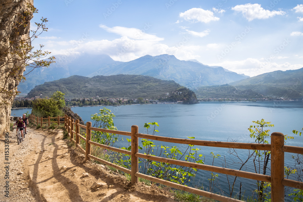 Fototapeta premium Cyclists run through the trail of Ponale in Riva del Garda, Italy.
