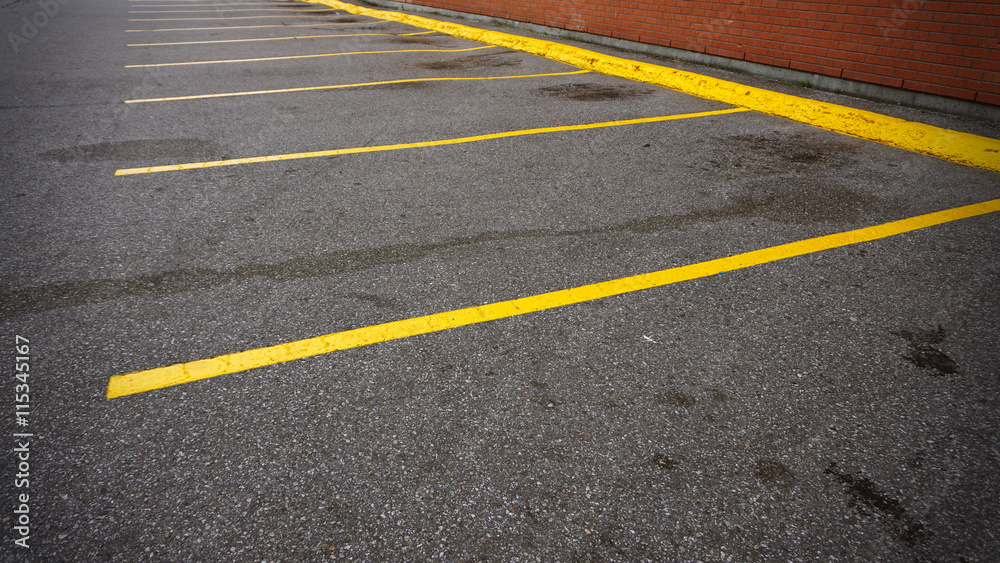 An empty parking spot with yellow lines beside the building