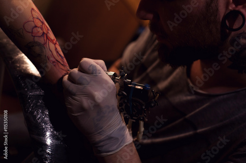 Tattoo artist works in salon © Dmitry Bairachnyi
