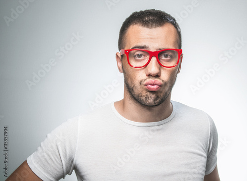 Annoying. Closeup portrait of dumb clueless young man,  who cares so what, I don't know. Isolated on gray - white background. Negative human emotion facial expression © Alen-D