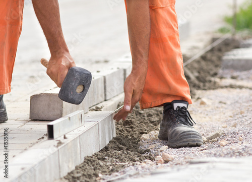 Worker instaling roadside blocks