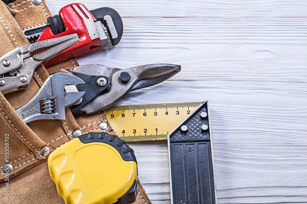 Construction tools in building belt on wooden board maintenance 