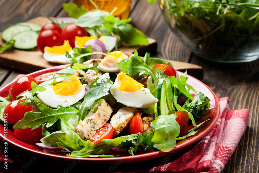 Fresh salad with chicken, tomatoes, eggs and arugula on plate Fresh salad with chicken, tomatoes, eggs and arugula on plate