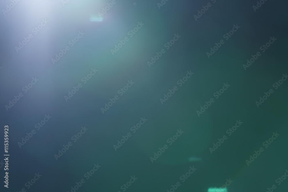 Fototapeta premium real green lens flare over dark background