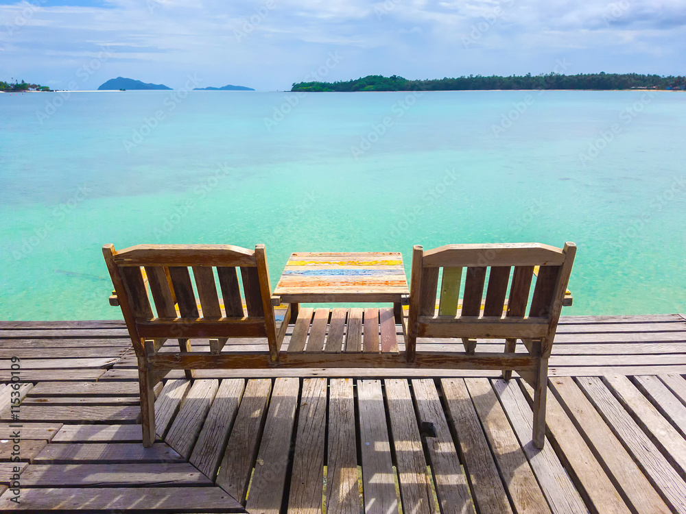 Couple beach chair on the sea beach wooden pier bridge, Thailand