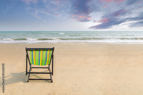 Beach chair on the white sand beach with sunset twilight sky and copy space. Summer background. Summer landscape concept. Romantic time in summer beach. Summer banner for label text or advertisement.