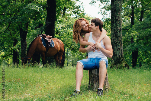 Lovers kissing and hugging on the background of horses