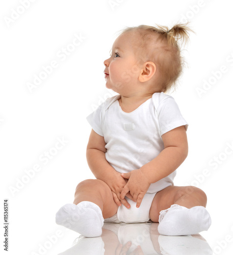 Infant child baby girl in diaper sitting happy looking at the co
