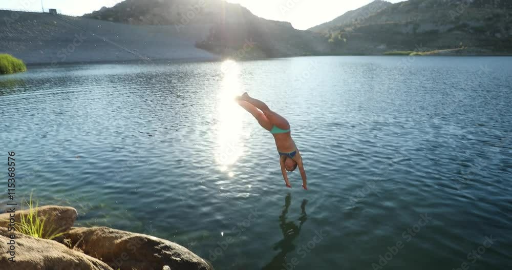 Young Woman Diving Into Lake At Sunset 
