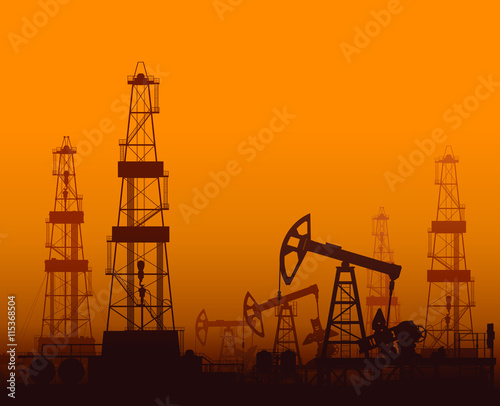 Drilling rigs and oil pumps at sunset