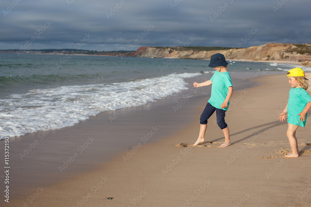 Two kids playing on sandy beach before rain
Two kids playing on sandy beach before rain
