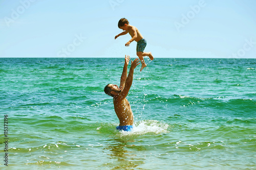 happy loving father and son playing outdoor on the coast