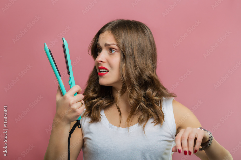 Beautiful woman with a wavy hair holding a hair iron Beautiful woman with a wavy hair holding a hair iron