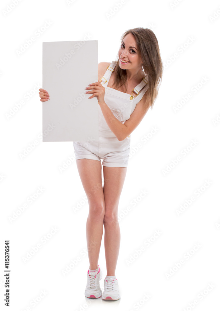 Beautiful sexy brunette girl in jeans shorts with a white sheet of paper isolated on white background. Beautiful young woman posing in studio smiling. Space for text. Beautiful sexy brunette girl in jeans shorts with a white sheet of paper isolated on white background. Beautiful young woman posing in studio smiling. Space for text.