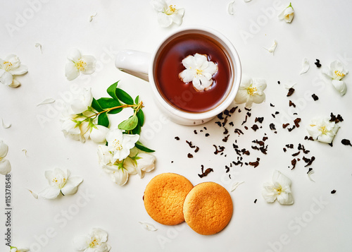 Tea cup with dried and fresh Jasmine flower and biscuits