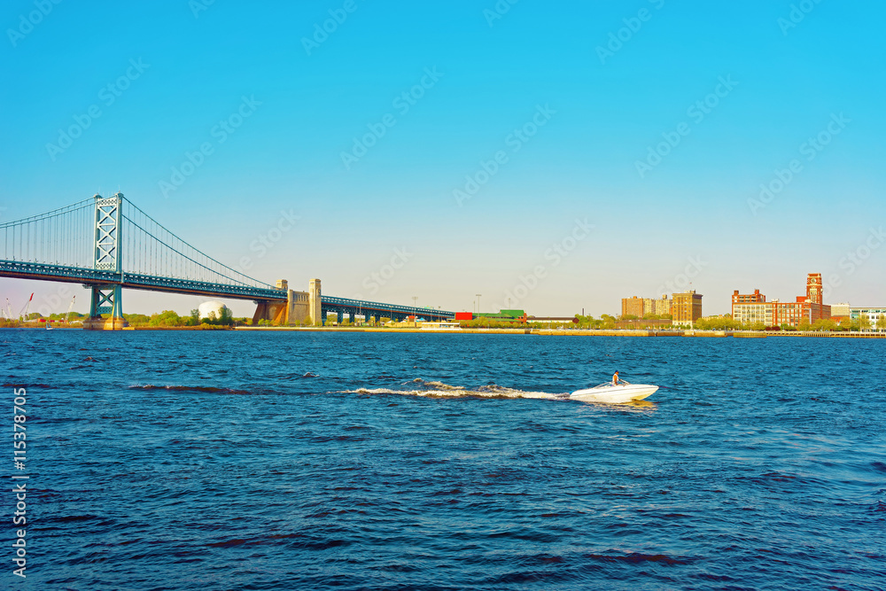 Boat at Benjamin Franklin Bridge over Delaware River in Philadelphia
