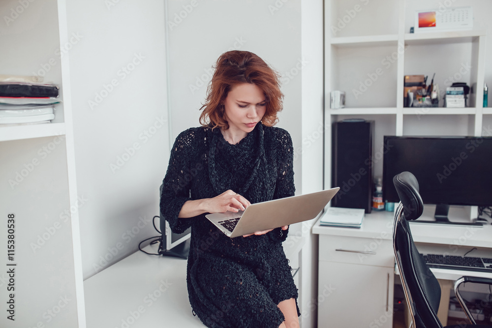 Young business woman with a computer in the office