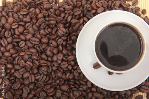 Coffee beans and a white cup on table