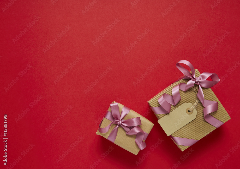 Birthday presents wrapped in brown paper with bows on a red background arranged to form a border